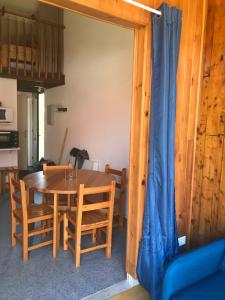 ein Esszimmer mit einem Holztisch und Stühlen in der Unterkunft Appartement chalet in Montferrier