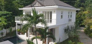 a white house with a swimming pool in front of it at Las Brisas Villa - Chateau Elysium in Beau Vallon