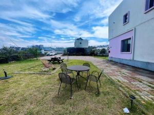 een tafel en stoelen op een tuin bij Living in Jeju Island in Jeju-stad