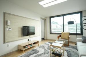 een woonkamer met een bank en een tv bij Living in Jeju Island in Jeju-stad