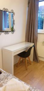 - un bureau blanc avec une chaise et un miroir dans l'établissement Apartament Turkusowy, à Szczecin