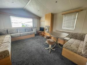 uma sala de estar com uma mesa e um sofá em 6 Berth Caravan With Wifi At Steeple Bay Holiday Park In Essex Ref 36092f em Southminster