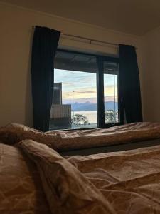 een slaapkamer met een raam met uitzicht op de stad bij Villa Nordheim in Tromsø