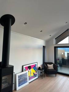 uma sala de estar com uma lareira preta e uma cadeira em Villa Nordheim em Tromsø