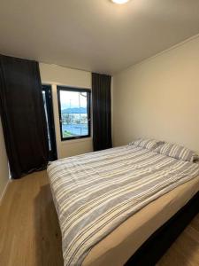 um quarto com uma cama grande e uma janela em Villa Nordheim em Tromsø
