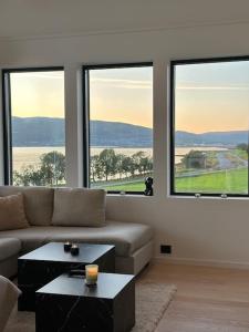 een woonkamer met een bank en 2 grote ramen bij Villa Nordheim in Tromsø