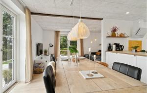 Beautiful Home In Sams With Kitchen في Ballen: غرفة طعام ومطبخ مع طاولة وكراسي
