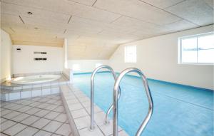 una piscina con bañera en una habitación en Amazing Home In Blvand With 5 Bedrooms, Sauna And Indoor Swimming Pool en Blåvand
