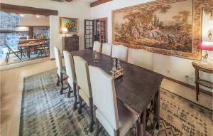 a dining room with a table and a large painting on the wall at Lovely Home In Cazouls-Lès-Béziers in Cazouls-lès-Béziers