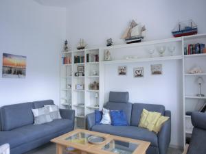 - un salon avec deux canapés bleus et une table basse dans l'établissement Ferienwohnung E8, à Graal-Müritz
