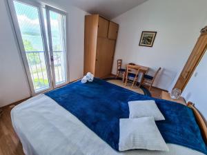 una camera da letto con un grande letto con una coperta blu di Apartment Hrastov a Soline