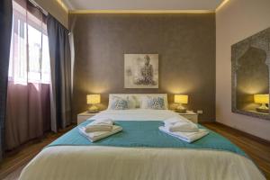 a bedroom with a large bed with towels on it at Villa Ghea - Indoor Jacuzzi Pool, Sauna and Games Room in Mellieħa