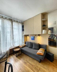 - un salon avec un canapé et une table dans l'établissement Quartier Latin Paris, à Paris