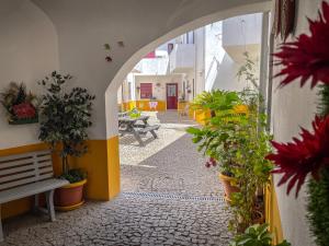 une allée avec des plantes en pot et un banc dans un bâtiment dans l'établissement Home Away From Home, à Évora