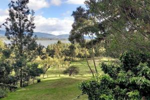een uitzicht op een veld met bomen en een meer bij Casa Tomine in Guatavita