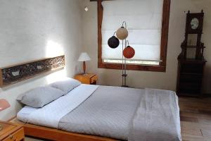 een slaapkamer met een bed en een klok aan de muur bij Casa Tomine in Guatavita