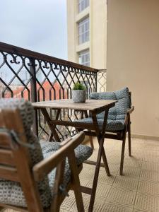 - Balcón con mesa de madera y 2 sillas en beautiful 2 bedrooms apartment with balcony, en Tel Aviv