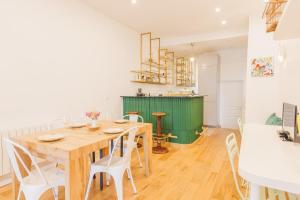 a dining room with a wooden table and white chairs at Cosy Loft between Montparnasse & Luxembourg Gardens in Paris