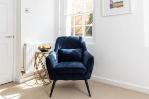 a blue chair sitting in a room with a window at 6 Elizabeth House - By Luxury Apartments in Cheltenham