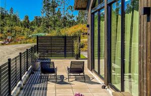2 chaises assises sur une terrasse avec fenêtres dans l'établissement Nice Home In Stathelle With Kitchen, à Stathelle
