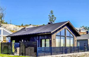 una casa con techo negro y valla azul en Nice Home In Stathelle With Kitchen, en Stathelle