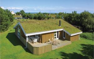 una pequeña casa con techo de hierba y terraza en 3 Bedroom Awesome Home In Sby, en Nordost