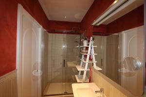 a bathroom with a shower and a sink and a mirror at Area Sacra Relais in Rome