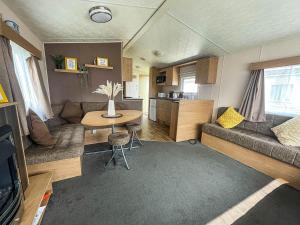 a living room with a couch and a table at Superb Caravan With Free Wifi At Seawick Holiday Park Ref 27022s in Clacton-on-Sea