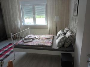 łóżko w sypialni z oknem w obiekcie Kuća Jovanka w mieście Zaječar
