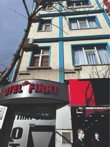 a tall building with a sign in front of it at Otel NİL FIRAT in Bursa