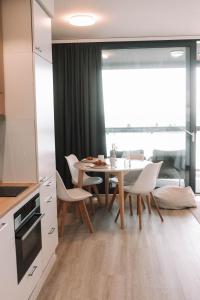 een keuken en eetkamer met een tafel en stoelen bij Matruusi - upea yksiö merinäköalalla - käytössäsi 2 maastopyörää in Kalajoki