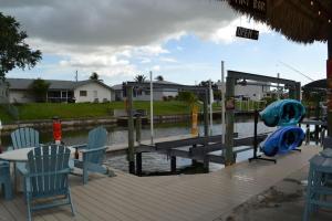 a wooden dock with chairs and a table and a marina at Heated pool, Family Fun, Tiki Bar, kayak, 3bd 2ba in Cape Coral