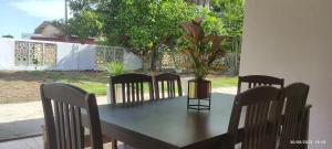 a table with chairs and a potted plant on it at HOMESTAY ALORSETAR TOWNCENTRE by ASTARILA GUESTHOUSE-StadiumDarulaman - iSLAM SAHAJA - Private Pool, BBQ Zone & Kolam Pancing Puyu - 8-13pax in Alor Setar