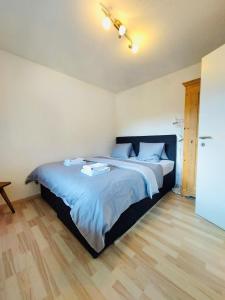 - une chambre dotée d'un grand lit avec des draps bleus dans l'établissement Rothornblick 63 by Arosa Holiday, à Arosa