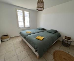 - une chambre avec un lit doté de 2 oreillers jaunes dans l'établissement Grande maison proche de la plage, à La Couarde-sur-Mer