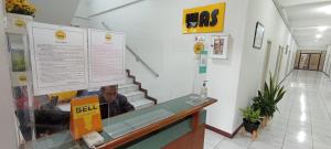 a man sitting at a counter in a store at Wisma Anton Soedjarwo in Areman