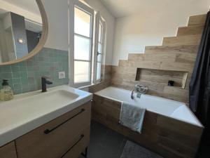La salle de bains est pourvue d'un lavabo, d'une baignoire et d'un miroir. dans l'établissement Grande maison proche de la plage, à La Couarde-sur-Mer