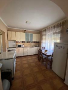 Apartmani Djurisic في مويكوفاتش: مطبخ مع دواليب بيضاء وطاولة مع كراسي