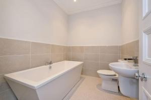 a bathroom with a tub and a toilet and a sink at Luxury West End Apartment in Aberdeen