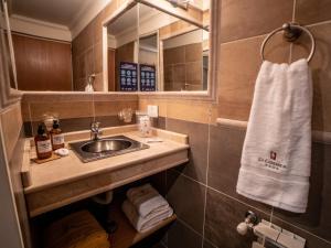 y baño con lavabo y espejo. en Resort de montaña - La Comarca en Villa La Angostura