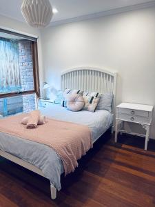 Un dormitorio con una cama grande con almohadas. en Gorgeous house near beach with nature view, en Frankston