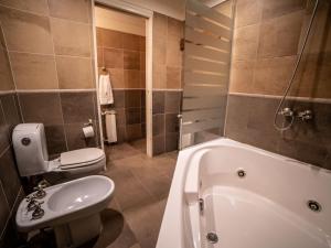 een badkamer met een bad, een toilet en een wastafel bij Resort de montaña - La Comarca in Villa La Angostura