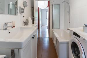 ein weißes Badezimmer mit 2 Waschbecken und einer Waschmaschine in der Unterkunft Casa Del Cactus - Bergamo City - by Host4U in Bergamo