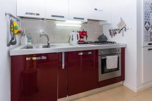 eine Küche mit roten Schränken und einem Waschbecken in der Unterkunft Casa Del Cactus - Bergamo City - by Host4U in Bergamo