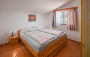 a bedroom with a wooden bed with a window at Lovely Apartment In Porec With Wifi in Poreč