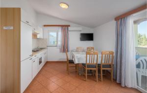 a kitchen and dining room with a table and chairs at Lovely Apartment In Porec With Wifi in Poreč
