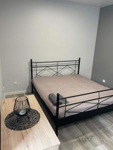 1 dormitorio con cama y mesa de madera en Apartamentai, en Raseiniai