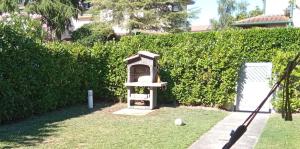 a bird feeder sitting in a yard next to a hedge at Luxury Villa Duna Verde in Duna Verde