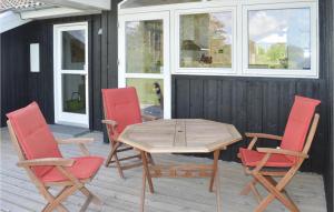 a wooden table and four chairs on a patio at Awesome Home In Jerup With 4 Bedrooms, Sauna And Wifi in Jerup