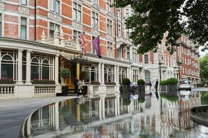 a building with a fountain in front of a street at Uber Mayfair Luxury Apartment in London